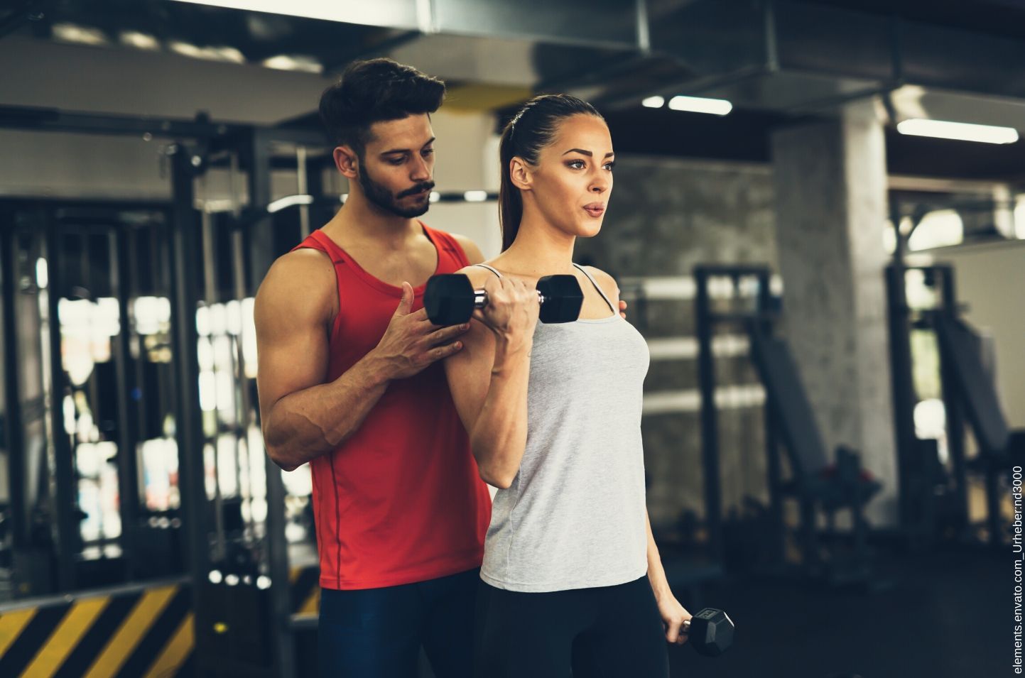 Personal Trainer betreut eine Frau für die er einen Trainingsplan erstellt hat.